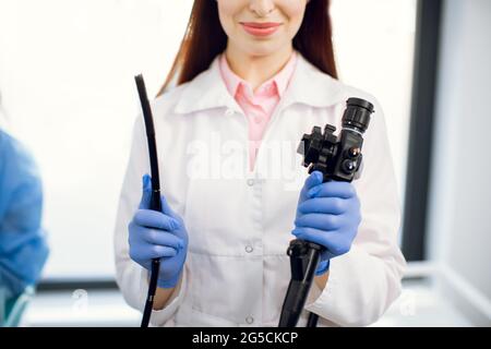 Concept d'endoscopie à fibres optiques gastro-intestinales. Prise de vue rapprochée de la femme médecin tenant un dispositif d'endoscope moderne avant l'examen de gastroscopie Banque D'Images