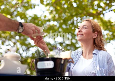 blonde blanche satisfaite recevant une tasse de café offerte par l'homme Banque D'Images