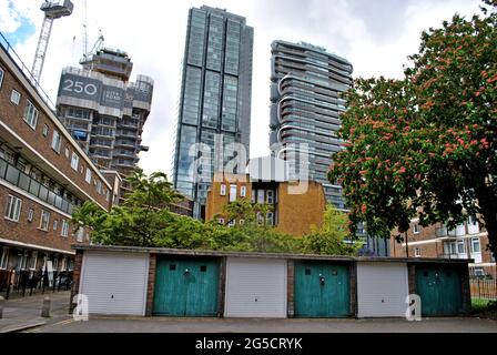 GARAGES DE FAIBLE HAUTEUR ET APPARTEMENTS DE CONSEIL AVEC DE NOUVELLES CONSTRUCTIONS DE LA VIEILLE RUE QUI LES DOMINENT. Banque D'Images