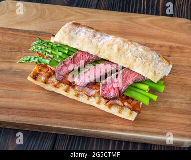 Sandwich avec asperges et tranches de steak de bœuf sur le panneau de bois Banque D'Images