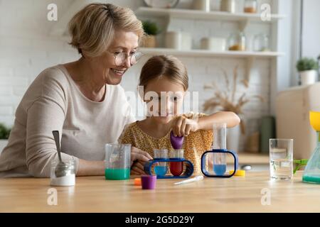 Bonne prise en charge grand-mère âgée faisant des tests chimiques avec Kid. Banque D'Images