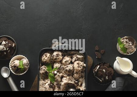 Crème glacée à la banane et aux biscuits maison dans un récipient prêt à manger sur fond noir. Espace pour le texte. Vue de dessus. Délicieux dessert propre, su Banque D'Images