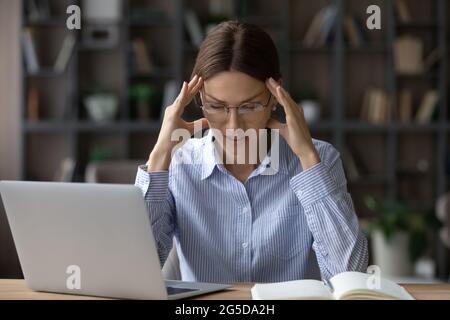 Une jeune femme malheureuse stressée souffrant de maux de tête. Banque D'Images