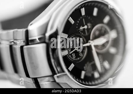 Gros plan noir et blanc monochrome d'une montre-bracelet homme solaire en titane et en métal Citizen Eco Drive montrant les mains de l'horloge et la sangle Banque D'Images