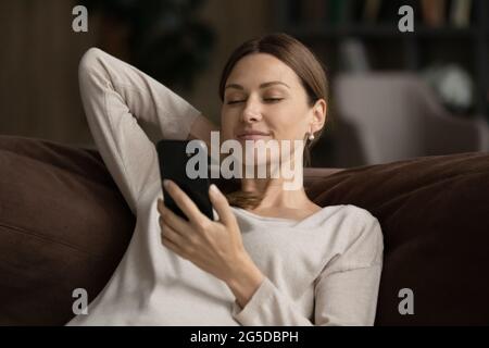 Décontracté souriant belle jeune femme utilisant un smartphone. Banque D'Images