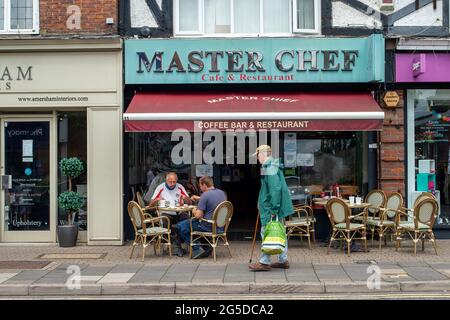 Amersham, Buckinghamshire, Royaume-Uni. 25 juin 2021. Les gens assis à l'extérieur d'un café. Les gens étaient dehors en appréciant les températures plus chaudes ce matin à Amersham alors que la ville revient à la vie après l'assouplissement de certaines des restrictions Covid-19. Le taux de cas positifs de Covid-19 pour 100,000 000, cependant, a augmenté dans les Chilterns à 70.9, (68) pour la semaine se terminant le 21 juin, par rapport à 39.6, (38) par rapport à la semaine précédente. Crédit : Maureen McLean/Alay Banque D'Images