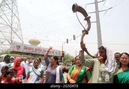 New Delhi, Inde. 26 juin 2021. Un agriculteur souffle une corne traditionnelle pendant la protestation des agriculteurs contre trois lois de réforme agricole à la frontière de Ghazipur.les agriculteurs assis sur les frontières de Delhi depuis sept mois sous la direction du syndicat des agriculteurs Samyukt Kisan Morcha. Les agriculteurs observent le 26 juin sous le nom de Kheti Bachao, Loktantra Bachao Diwas (Save Agriculture, Save Democracy Day). Les agriculteurs exigent également de définir légalement le MSP (prix de soutien minimum). Crédit : SOPA Images Limited/Alamy Live News Banque D'Images