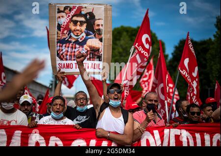 Novara, Italie. 26 juin 2021. Les manifestants font un geste lors d'une manifestation organisée par le syndicat si Cobas pour protester contre le meurtre d'Adil Belakhdim. Le syndicaliste Adil Belakhdim est décédé vendredi 18 juin après avoir été frappé par un camion qui a forcé le blocus organisé par les travailleurs lors d'une grève devant l'entrepôt de Lidl à Biandrate, près de Novara. Credit: Nicolò Campo/Alay Live News Banque D'Images