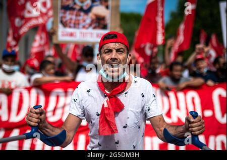 Novara, Italie. 26 juin 2021. Un manifestant se crie lors d'une manifestation organisée par le syndicat si Cobas pour protester contre le meurtre d'Adil Belakhdim. Le syndicaliste Adil Belakhdim est décédé vendredi 18 juin après avoir été frappé par un camion qui a forcé le blocus organisé par les travailleurs lors d'une grève devant l'entrepôt de Lidl à Biandrate, près de Novara. Credit: Nicolò Campo/Alay Live News Banque D'Images