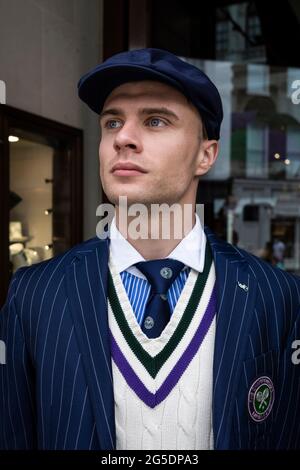 Londres, Royaume-Uni. 26 juin 2021. Un membre du personnel vêtu d'un arbitre devant le magasin Ralph Lauren de New Bond Street, décoré en prévision des prochains championnats de tennis de Wimbledon de cette année au club All England. Ralph Lauren fournit des tenues pour les officiels de l'événement. Les restrictions de confinement limiteront les foules, mais les finales seront à pleine capacité lorsque les restrictions seront assouplies. Credit: Stephen Chung / Alamy Live News Banque D'Images