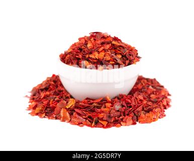 Flocons de piment rouge séchés dans un bol, isolés sur fond blanc. Piment de Cayenne haché. Épices et herbes. Banque D'Images