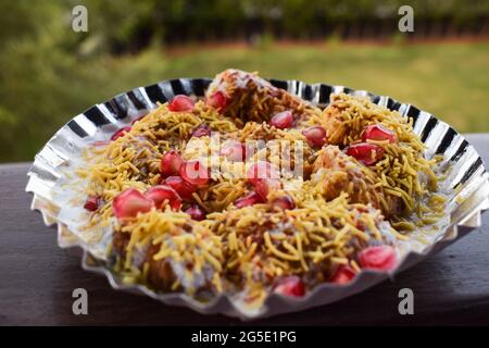 Dahi bhalla bhel chaat garni de sev, graines de grenade, chaat masala avec sauces sucrées et aigres. Des collations maison de chaat indien sont servies dans la rue f Banque D'Images