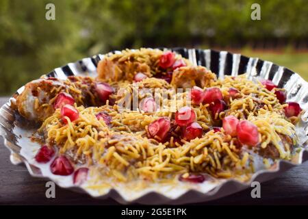 Dahi bhalla bhel chaat garni de sev, graines de grenade, chaat masala avec sauces sucrées et aigres. Des collations maison de chaat indien sont servies dans la rue f Banque D'Images