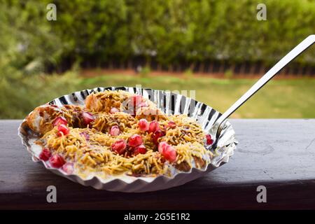 Dahi bhalla bhel chaat garni de sev, graines de grenade, chaat masala avec sauces sucrées et aigres. Des collations maison de chaat indien sont servies dans la rue f Banque D'Images