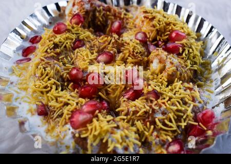 Dahi bhalla bhel chaat garni de sev, graines de grenade, chaat masala avec sauces sucrées et aigres. Des collations maison de chaat indien sont servies dans la rue f Banque D'Images