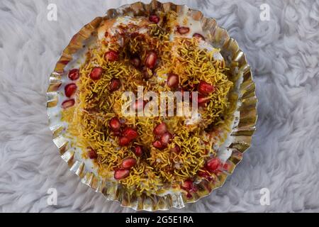 Dahi bhalla bhel chaat garni de sev, graines de grenade, chaat masala avec sauces sucrées et aigres. Des collations maison de chaat indien sont servies dans la rue f Banque D'Images