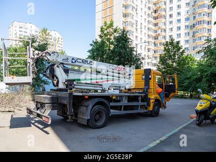 Une voiture avec un ascenseur hydraulique dans la cour d'un immeuble résidentiel. Le travail de la ville de services publics, Moscou, Russie Banque D'Images