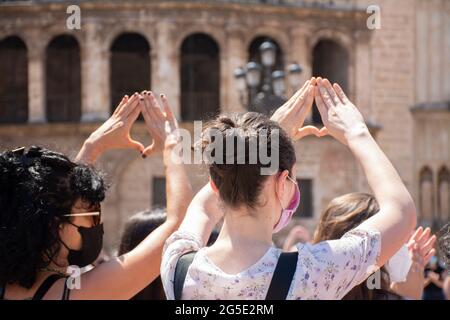 Valence Espagne. 26 juin 2021 - deux femmes faisant un symbole féministe avec leurs mains dans une protestation en défense des droits des femmes, avec la cathédrale Banque D'Images