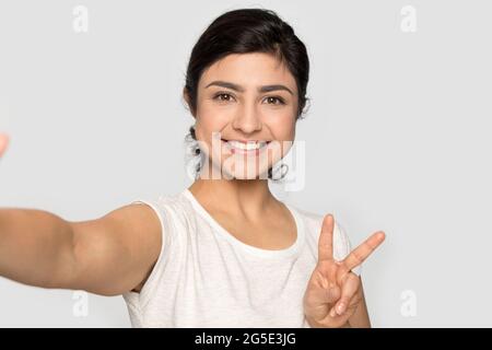 Une femme indienne souriante fait un autoportrait en studio Banque D'Images