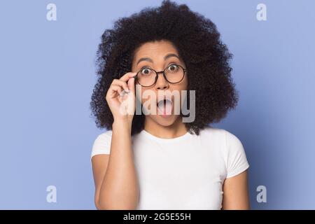 Femme biraciale stupéfait dans des verres choqués par l'offre de vente Banque D'Images