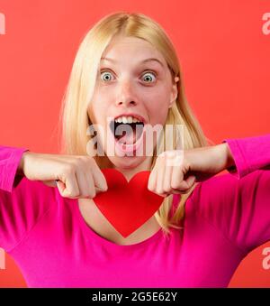 Belle fille déchirant rouge papier coeur. Rupture de relations. Problèmes de relations. Un amour sans demande. Banque D'Images