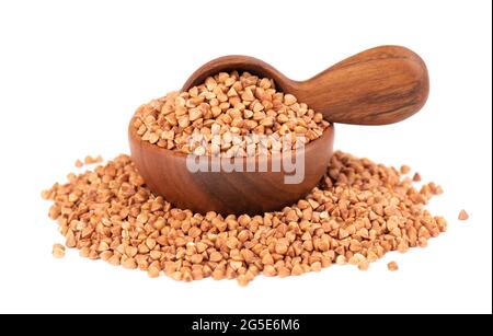 Grains de sarrasin rôtis dans un bol et une cuillère en bois, isolés sur fond blanc. Gruaux de sarrasin brun sec. Banque D'Images