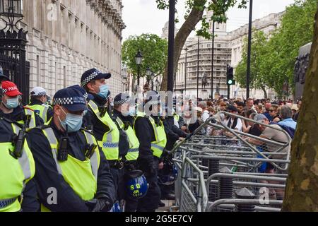 Londres, Royaume-Uni. 26 juin 2021. La police anti-émeute observe les manifestants à l'extérieur de Downing Street pendant la manifestation. Des manifestants anti-verrouillage et anti-vaccination se sont de nouveau rassemblés dans le centre de Londres pour protester contre d'autres blocages, masques et passeports de vaccination. Crédit : SOPA Images Limited/Alamy Live News Banque D'Images