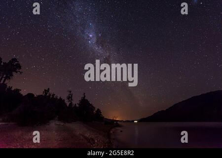 Ciel étoilé la nuit dans le parc national de Los Alerces. On peut voir le lac Rivadavia. Banque D'Images