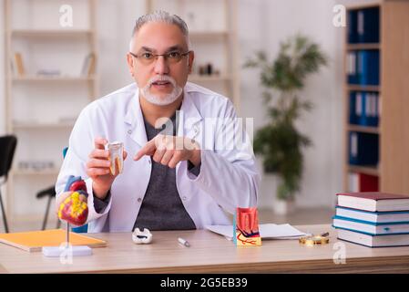 Ancien professeur de dentiste assis dans la salle de classe Banque D'Images