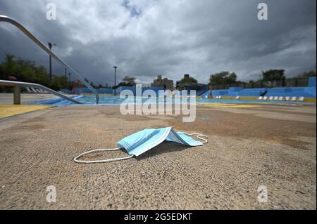 New York, États-Unis. 26 juin 2021. Un masque facial jeté se trouve sur le bord de la piscine Kosciuszko alors que la ville de New York rouvre ses piscines publiques extérieures, ce jour-là, dans le quartier de Brooklyn à New York, NY, le 26 juin 2021. 48 des piscines extérieures de New York rouvriront dans les cinq quartiers, ouvertes de 11 h à 15 h et fermées pour une heure de nettoyage, puis rouvriront à 16 h jusqu'à 19 h. les visiteurs devront porter un masque facial sauf dans l'eau. (Photo par Anthony Behar/Sipa USA) crédit: SIPA USA/Alay Live News Banque D'Images