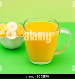 Smoothie orange, banane et mangue dans un mug en verre Banque D'Images