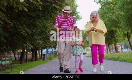 Grand-père de grand-mère senior souriant avec petite-fille jouant le jeu de jouet anti-stress de compression Banque D'Images