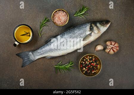 Gros plan sur une table de poisson frais brut de mer européenne, avec sel, grains de poivre, romarin, ail et huile d'olive, vue en hauteur, directement au-dessus Banque D'Images