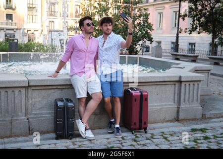 Couple de touristes prenant un selfie à la fontaine dans une place de la ville. Banque D'Images