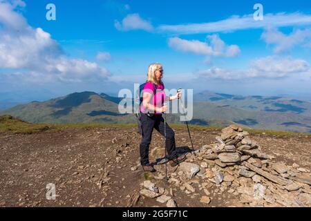 Walker au sommet du cairn de la montagne munro de Meall Corranaich, une partie de la chaîne Ben Lawers en Écosse. La crête de Tarmachan est arrière-plan gauche Banque D'Images