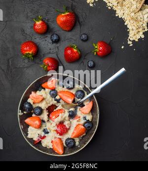 Le concept d'un petit déjeuner sain de flocons d'avoine avec des fraises et des bleuets Banque D'Images