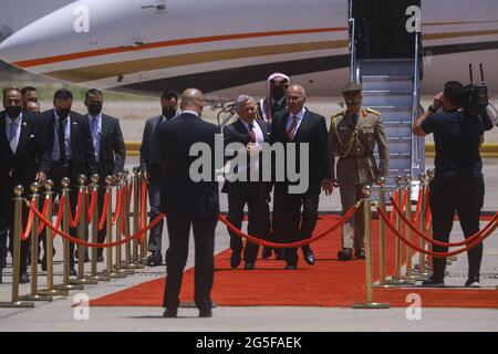 Bagdad, Irak. 27 juin 2021. Le Président iraquien Barham Salih (centre R) reçoit le roi Abdallah II de Jordanie (centre L) lors de la cérémonie d'accueil à l'aéroport international de Bagdad, avant le sommet tripartite entre l'Irak, l'Égypte et la Jordanie. Credit: Ameer Al Mohmmedaw/dpa/Alay Live News Banque D'Images