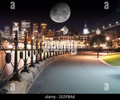 Vue panoramique sur le port de Sydney la nuit avec une grande lune dans le ciel nocturne au-dessus du quartier des affaires de Sydney, Nouvelle-Galles du Sud, Australie et du bâtiment du port Bridge Banque D'Images