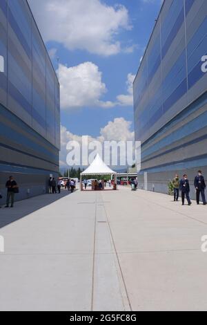 Long chemin de promenade en béton entre deux grands bâtiments dans une journée ensoleillée avec des nuages Banque D'Images