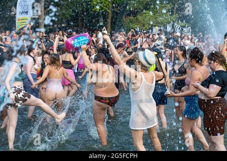 Les participants célèbrent la fête à la fontaine du parc Washington Square à la fin de la marche à New York. Des milliers de personnes défilent pendant la 29e marche annuelle de la digue de New York. La Marche du Dyke, qui s'appelle une manifestation de mars, plutôt qu'une parade, est une 'démonstration de notre droit de protestation du premier amendement' selon leur site Internet. En raison de la pandémie du coronavirus, la marche a eu lieu pratiquement en 2020. La marche de cette année a commencé à Bryant Park et s'est terminée à Washington Square Park. Banque D'Images