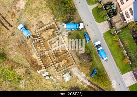 Vue aérienne de haut en bas des travaux de construction de la fondation en béton de la maison neuve dans la zone résidentielle rurale. Banque D'Images