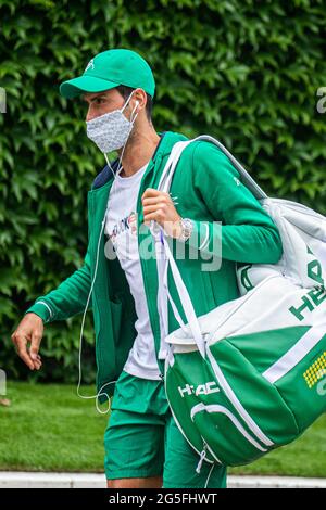 WIMBLEDON LONDRES 27 juin 2021. Le champion défenseur Novak Djokovic portant un masque arrive pour la pratique au club de toute l'Angleterre à la veille des championnats de Wimbledon qui débutent le lundi 28 juin 2021. Le tournoi de l'année dernière a été annulé en raison de la pandémie Covid-19 pour la première fois depuis la deuxième guerre mondiale et aura lieu du 28 juin au 11 juillet avec une capacité réduite de 50 %. Seuls les spectateurs ayant des billets précommandés seront autorisés et aucun campement ou file d'attente de nuit ne sera autorisé. Credit: amer ghazzal / Alamy Live News Banque D'Images