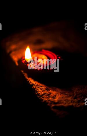 Gros plan de Diva ou divida en feu, de Diya ou de lampe à huile isolée dans l'obscurité. Banque D'Images