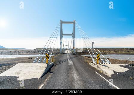 Étroit pont de suptension le long d'une route dans un endroit isolé dans le nord de l'Islande lors d'une journée d'été claire Banque D'Images