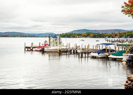 Pompe à essence pour bateaux à l'extrémité d'une jetée en bois dans une marina sur un lac lors d'un jour d'automne couvert Banque D'Images