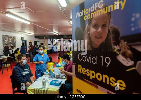 Watford, Royaume-Uni. 27 juin 2021. Vue générale de la clinique pop-up de vaccination de masse au stade Vicarage Road du FC Watford dans le cadre de la campagne « Grab a jab ». Le NHS fait également la promotion ce week-end d'un certain nombre de cliniques sans rendez-vous dans la capitale pour tenter d'augmenter le nombre de plus de 18 personnes recevant un jab, car les cas de la variante Delta sont en hausse. Credit: Stephen Chung / Alamy Live News Banque D'Images