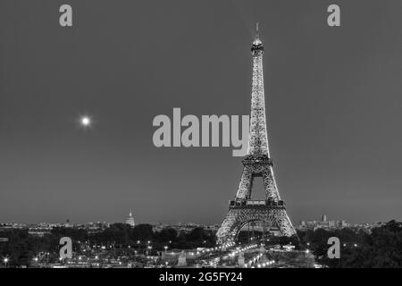 Feux de signalisation menant à une Tour Eiffel illuminée la nuit à Paris, France Banque D'Images