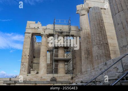 Colonnes à l'entrée de l'Acropole à Athènes Grèce avec échafaudage en métal construit autour d'une colonne en cours de réparation avec un magnifique fond bleu ciel Banque D'Images