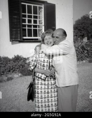 Années 1960, historique, une élégante jeune anglaise qui reçoit un vrai italien 'Benvenuto', un accueil chaleureux et un grand câlin, d'un homme italien plus âgé, l'Italie. Le peuple italien est connu pour sa nature amicale et son hospitalité. Banque D'Images