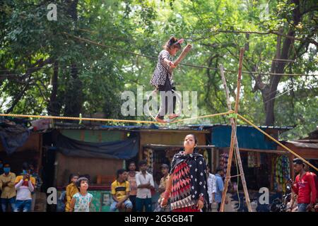 New Delhi, Inde. 27 juin 2021. Une fille indienne non identifiée fait des acrobaties de rue en marchant sur une corde dans une exécution pour gagner un gagne-pain. Crédit : SOPA Images Limited/Alamy Live News Banque D'Images